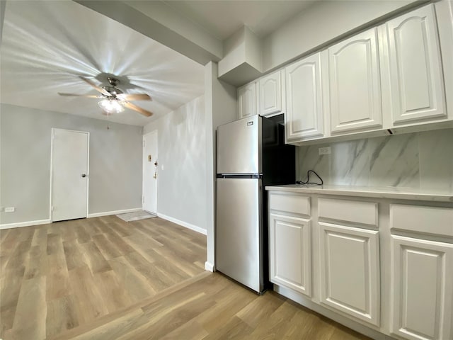 kitchen featuring white cabinetry, ceiling fan, stainless steel fridge, and light hardwood / wood-style floors