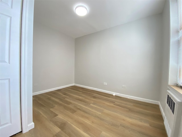 spare room featuring hardwood / wood-style flooring and radiator heating unit