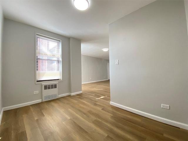 empty room featuring hardwood / wood-style flooring and radiator