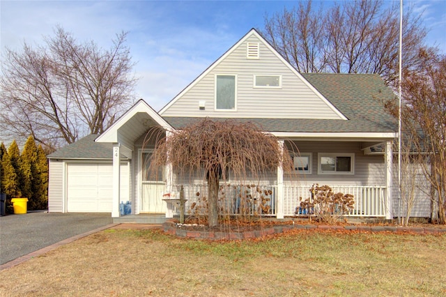 view of front facade featuring a garage, a front lawn, and covered porch