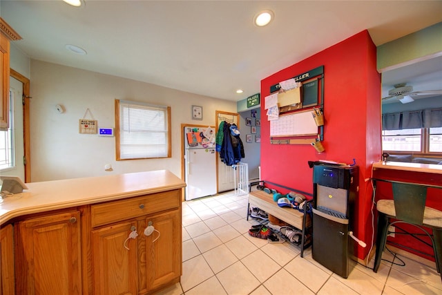 kitchen featuring light tile patterned flooring, white fridge, and ceiling fan