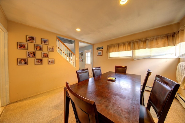 dining space with light colored carpet and a baseboard radiator