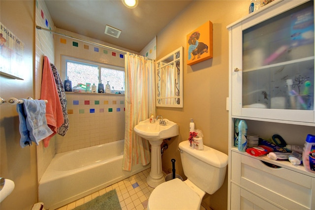 bathroom featuring shower / bathtub combination with curtain, tile patterned flooring, and toilet