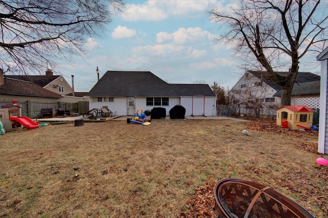 rear view of property with a playground, a patio, and a lawn