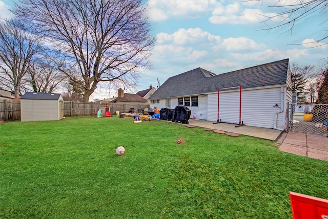 view of yard with an outbuilding, a storage unit, and a fenced backyard