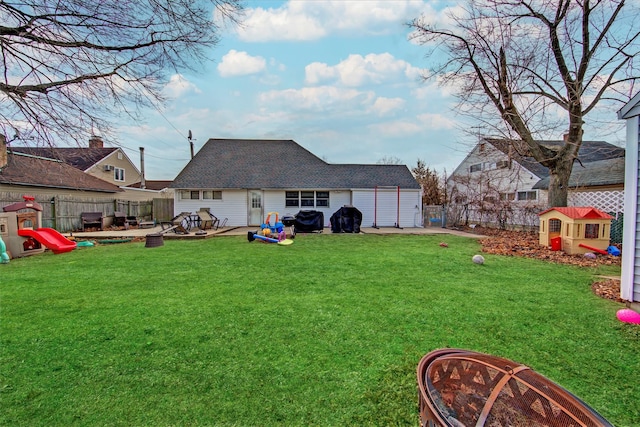 view of yard featuring an outdoor fire pit, a fenced backyard, an outdoor structure, and a wooden deck