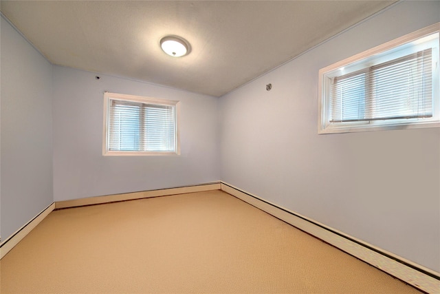 unfurnished room with baseboards, baseboard heating, carpet flooring, and a healthy amount of sunlight