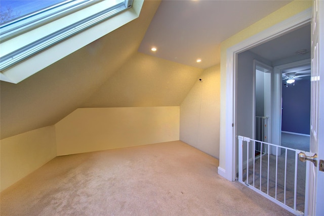 additional living space featuring carpet floors, vaulted ceiling with skylight, and recessed lighting