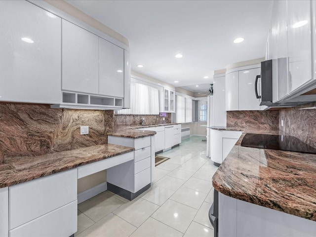 kitchen featuring decorative backsplash, black electric stovetop, white cabinets, and dark stone counters