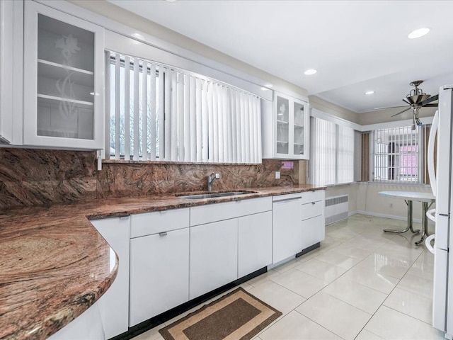 kitchen featuring white appliances, radiator, sink, and white cabinets