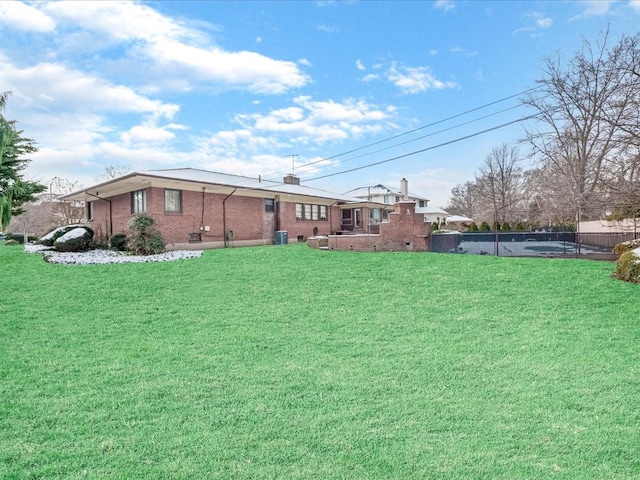 view of yard with central AC unit and a swimming pool