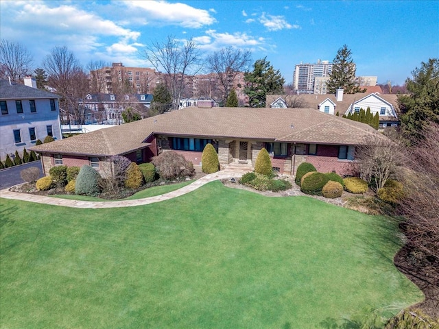 ranch-style home featuring a front lawn and brick siding