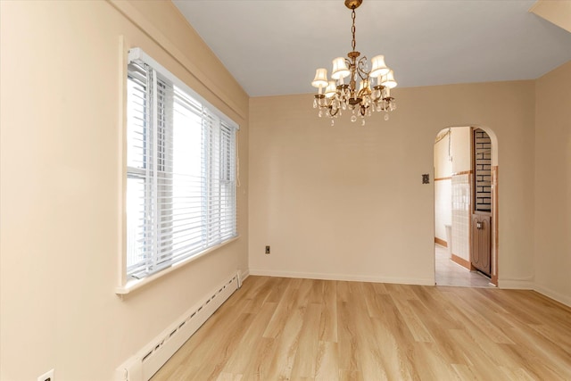 spare room with baseboard heating, an inviting chandelier, and light hardwood / wood-style flooring