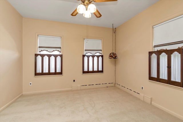 carpeted empty room with a wealth of natural light, ceiling fan, and baseboard heating