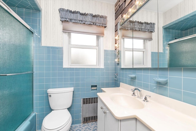 full bathroom with a healthy amount of sunlight, toilet, radiator, and vanity