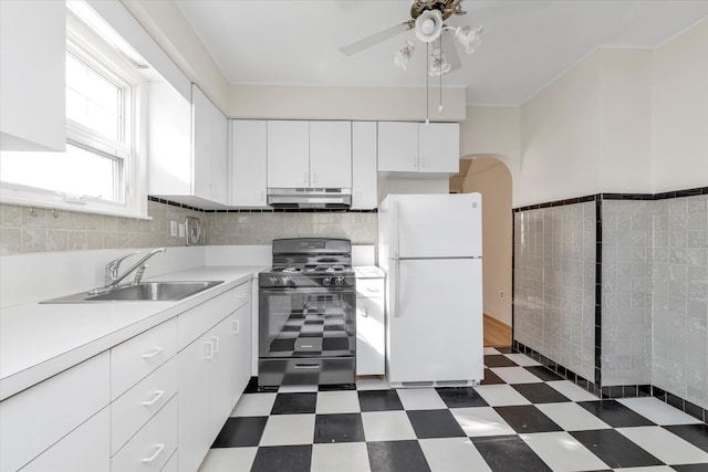 kitchen with sink, white cabinets, white fridge, ceiling fan, and black gas range