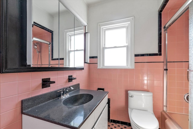 full bathroom with vanity, tile walls, shower / bath combination with glass door, and toilet