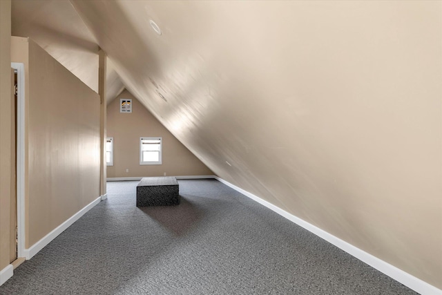 bonus room with vaulted ceiling and carpet flooring