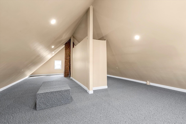 additional living space featuring vaulted ceiling and carpet