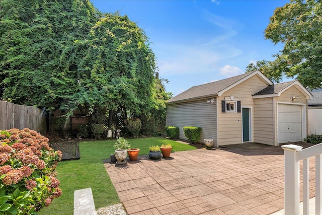 view of patio featuring a garage and an outbuilding