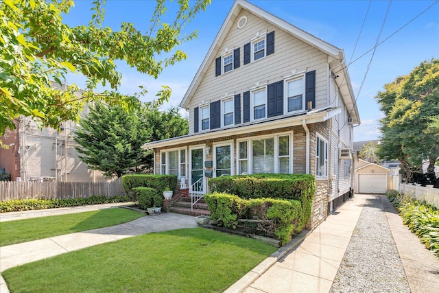 view of front property featuring a garage, an outdoor structure, and a front lawn