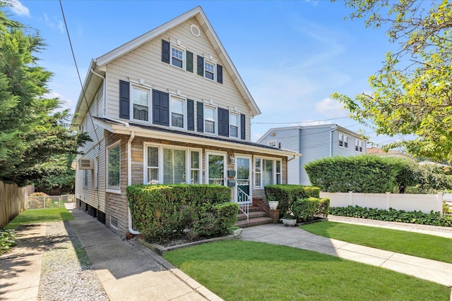 view of front facade featuring a front lawn and an AC wall unit