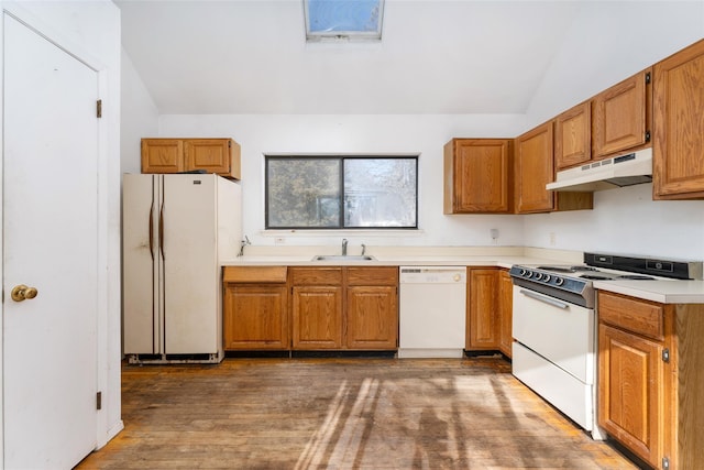 kitchen featuring sink, white appliances, dark wood-type flooring, and vaulted ceiling