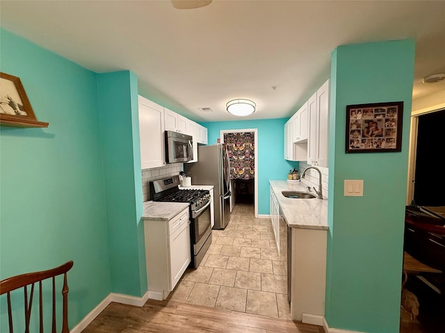 kitchen featuring stainless steel appliances, sink, and white cabinets