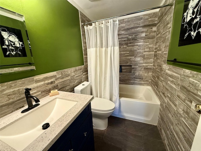 full bathroom with tile walls, shower / tub combo, vanity, and toilet