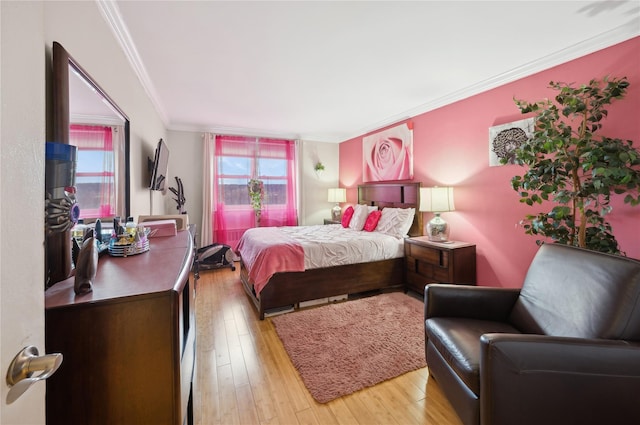 bedroom with ornamental molding and light hardwood / wood-style flooring