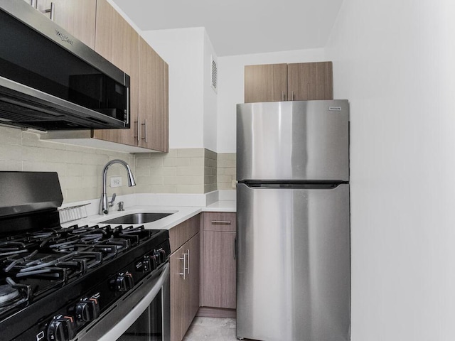 kitchen with tasteful backsplash, stainless steel appliances, and sink