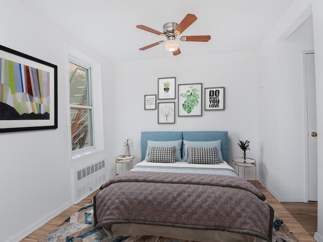 bedroom featuring radiator, ceiling fan, and light hardwood / wood-style floors