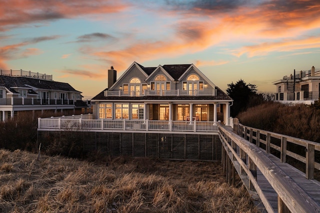 back house at dusk with a balcony