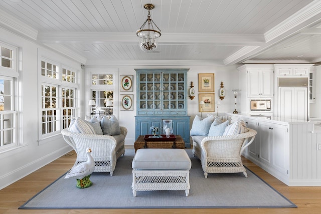 sitting room featuring light hardwood / wood-style flooring, ornamental molding, and beamed ceiling