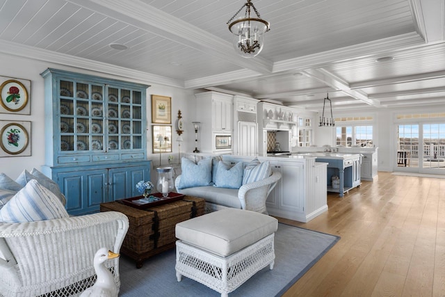 living room featuring an inviting chandelier, light hardwood / wood-style flooring, ornamental molding, and beamed ceiling