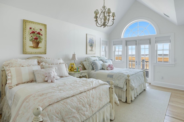 bedroom featuring french doors, multiple windows, access to exterior, and light hardwood / wood-style flooring