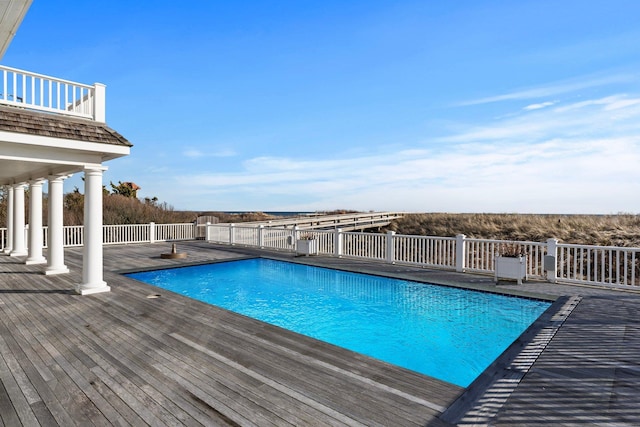 view of swimming pool featuring a wooden deck and a patio