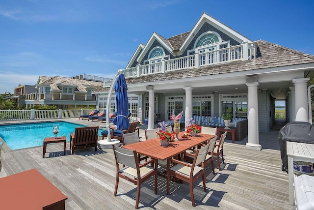 exterior space featuring an outdoor living space, a balcony, and a swimming pool side deck