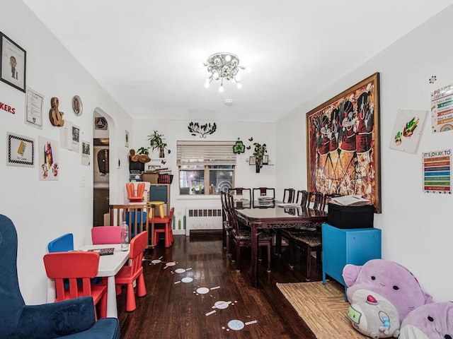 dining space with dark wood-type flooring and radiator