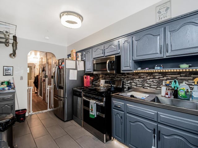 kitchen with tasteful backsplash, appliances with stainless steel finishes, and light tile patterned floors