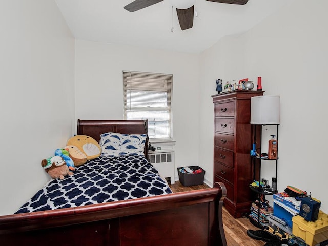 bedroom with radiator, ceiling fan, and light hardwood / wood-style flooring