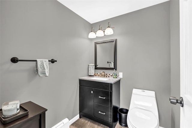 bathroom featuring baseboard heating, vanity, and toilet