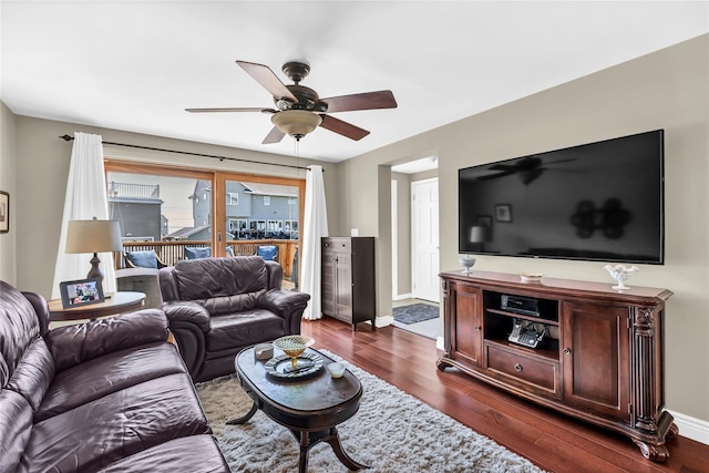 living room with ceiling fan and dark hardwood / wood-style flooring