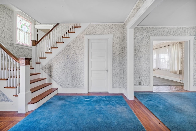 entryway featuring ornamental molding and dark hardwood / wood-style floors