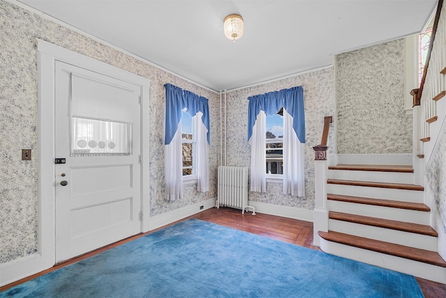 foyer featuring dark wood-type flooring and radiator