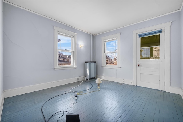 spare room featuring dark hardwood / wood-style floors and radiator