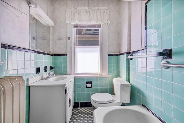 bathroom with vanity, tile walls, and toilet