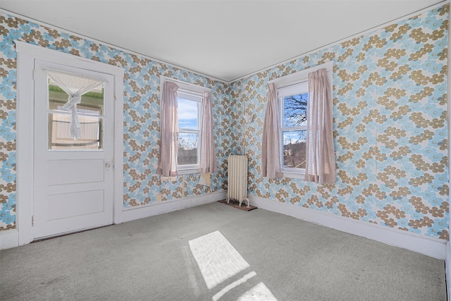 unfurnished room featuring light colored carpet and radiator heating unit