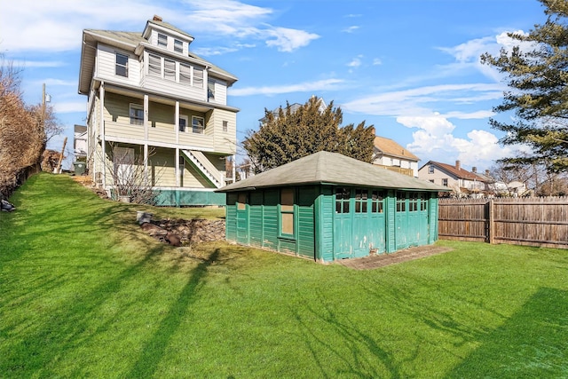 rear view of property with a shed and a lawn