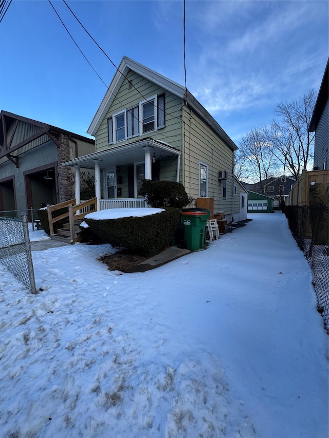 snow covered property featuring covered porch